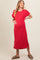 woman wearing a red ribbed maternity dress with short sleeves and side slits, holding her baby bump