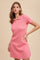 woman wearing a fitted pink short sleeve polo dress with a collar
