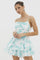 woman wearing a floral print mini dress with layered ruffles in shades of blue and white