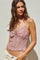 woman wearing a pink floral crop top with a smocked bodice and adjustable spaghetti straps