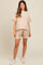 woman wearing a beige ribbed maternity top and matching shorts with a relaxed fit