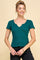 woman wearing a dark green short sleeve fitted top with a scalloped hem and v-neck neckline