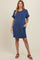 woman wearing a navy blue striped maternity dress with pockets and short sleeves, standing casually