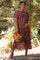 woman wearing a floral pleated maternity dress and holding a bouquet, with a visible baby bump
