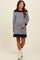 woman wearing a navy and white striped maternity dress with a relaxed fit and long sleeves, showing her baby bump