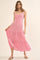 woman wearing a pink and white striped maxi dress with buttons and tiered skirt, styled with sandals