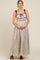 woman wearing a floral maternity maxi dress with black straps, holding her baby bump