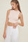 woman wearing a light pink ribbed cropped tank top and white high-waisted pants