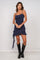 woman wearing a navy blue spaghetti strap mini dress with ruffle details and black knee-high boots