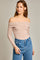 woman wearing a nude off-the-shoulder long sleeve bodysuit and high-waisted blue jeans