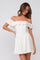woman wearing a white off-the-shoulder mini dress with ruffle details and a fitted bodice