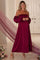 woman wearing a burgundy off-the-shoulder maternity dress with puff sleeves and a visible baby bump