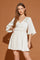 woman wearing a cream v-neck mini dress with bell sleeves and a cinched waist