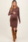 woman wearing a brown ribbed maternity dress with buttons and showing her baby bump, paired with tall suede boots