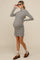 woman wearing a grey and white striped maternity dress with a high neckline and baby bump visible