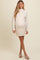 woman wearing a beige maternity sweater dress with a high neckline and long sleeves, showcasing a visible baby bump