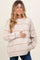 woman wearing a beige striped maternity sweater and holding her baby bump