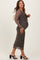 woman wearing a black and brown leopard print maternity dress with long sleeves and a visible baby bump