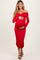 woman wearing a red off-shoulder maternity dress with ruching and holding her baby bump