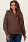 woman wearing a brown textured maternity sweater with a half-zip and relaxed fit, smiling at the camera