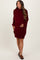 woman wearing a burgundy maternity sweater dress with a relaxed fit and long sleeves, holding her baby bump