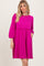 woman wearing a hot pink short sleeve dress with a cinched waist and pockets, styled with flowing sleeves