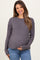 woman wearing a grey maternity sweater with ribbed sleeves and holding her baby bump