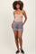 woman wearing a nude tank top and gray maternity shorts with pockets, standing confidently
