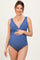 woman wearing a blue maternity swimsuit with scalloped details and holding her baby bump