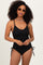 woman wearing a black ribbed one-piece swimsuit with adjustable straps and side ties