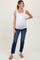 woman wearing a white maternity tank top and blue jeans, highlighting her baby bump