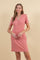 woman wearing a pink short sleeve dress with a v-neck and button details