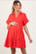 woman wearing a red short sleeve maternity dress with a tiered design and a visible baby bump