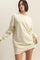 woman wearing a cream oversized sweatshirt dress with long sleeves and a relaxed fit