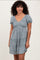 woman wearing a blue floral puff sleeve mini dress with a v-neckline and A-line silhouette