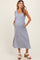 woman wearing a striped maternity dress with pockets and a fitted bodice, showcasing her baby bump