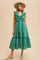 woman wearing a green floral midi dress with ruffled sleeves and a tied waist, paired with a straw hat and shoes