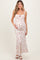woman wearing a white floral maternity maxi dress and holding her baby bump