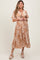 woman wearing a brown and white patterned maternity dress with short sleeves and a tie detail at the waist