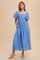 woman wearing a light blue maxi dress with puff sleeves and pockets, styled with strappy heels