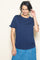 woman wearing a navy blue short sleeve top with ruffle details and a denim skirt