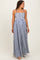 woman wearing a navy and white striped maternity maxi dress with a smocked bodice and adjustable straps, showing a baby bump