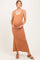 woman wearing a rust-colored maternity maxi dress and holding her baby bump