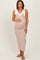 woman wearing a cream and multi-colored zigzag patterned maternity dress with tie straps and a visible baby bump