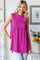 woman wearing a vibrant fuchsia sleeveless top with a relaxed fit and gathered waist, smiling against a neutral backdrop