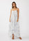 woman wearing a blue and white floral maxi dress with a hi-low hem and adjustable spaghetti straps