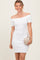 woman wearing a white off-the-shoulder bodycon dress and holding a gold clutch bag