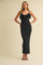 woman wearing a black sleeveless maxi dress with ruffle details and a tie at the neckline