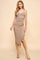 woman wearing a beige ribbed midi dress with thin straps and a ruffled hem, paired with nude sandals
