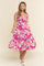 woman wearing a pink floral midi dress with tie straps and a tiered skirt